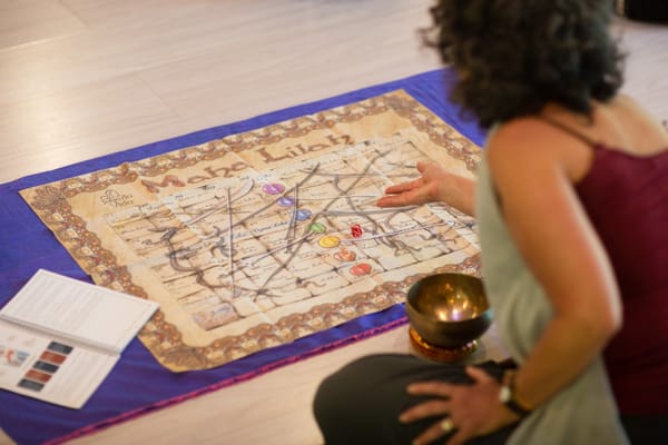 The game board on the floor, Zaida sitting talking about it